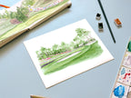 golf landscape tournament watercolor archival print laying on a desk with a sketchbook