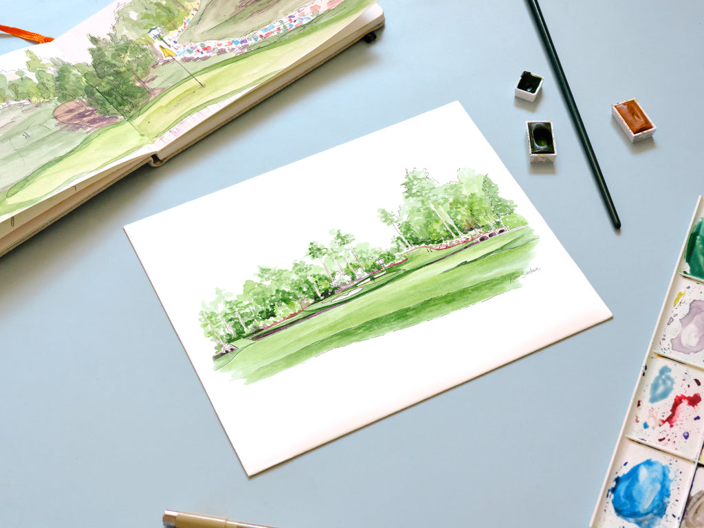 golf landscape georgia watercolor archival print laying on a desk with a sketchbook