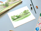 golf landscape green watercolor archival print laying on a desk with a sketchbook