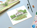 golf landscape watercolor archival print laying on a desk with a sketchbook