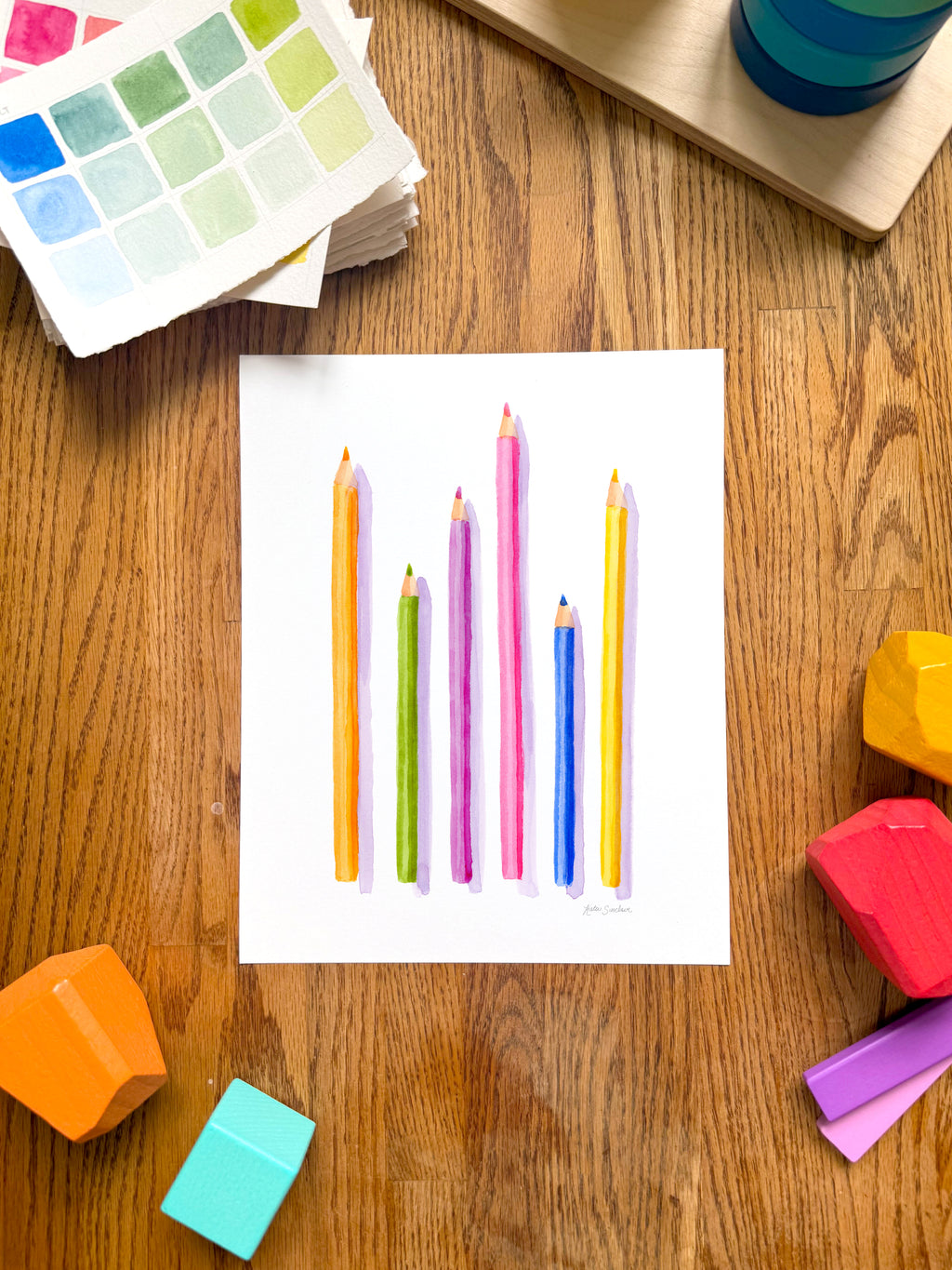 colorful watercolor of pencils archival print, surrounded by geometric toys on a wooden surface.  hand-painted by katie sinclair and perfect for a playroom or kid bedroom.