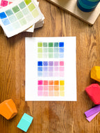 colorful watercolor swatch art print, surrounded by geometric toys on a wooden surface.  hand-painted by katie sinclair and perfect for a playroom or kid bedroom.