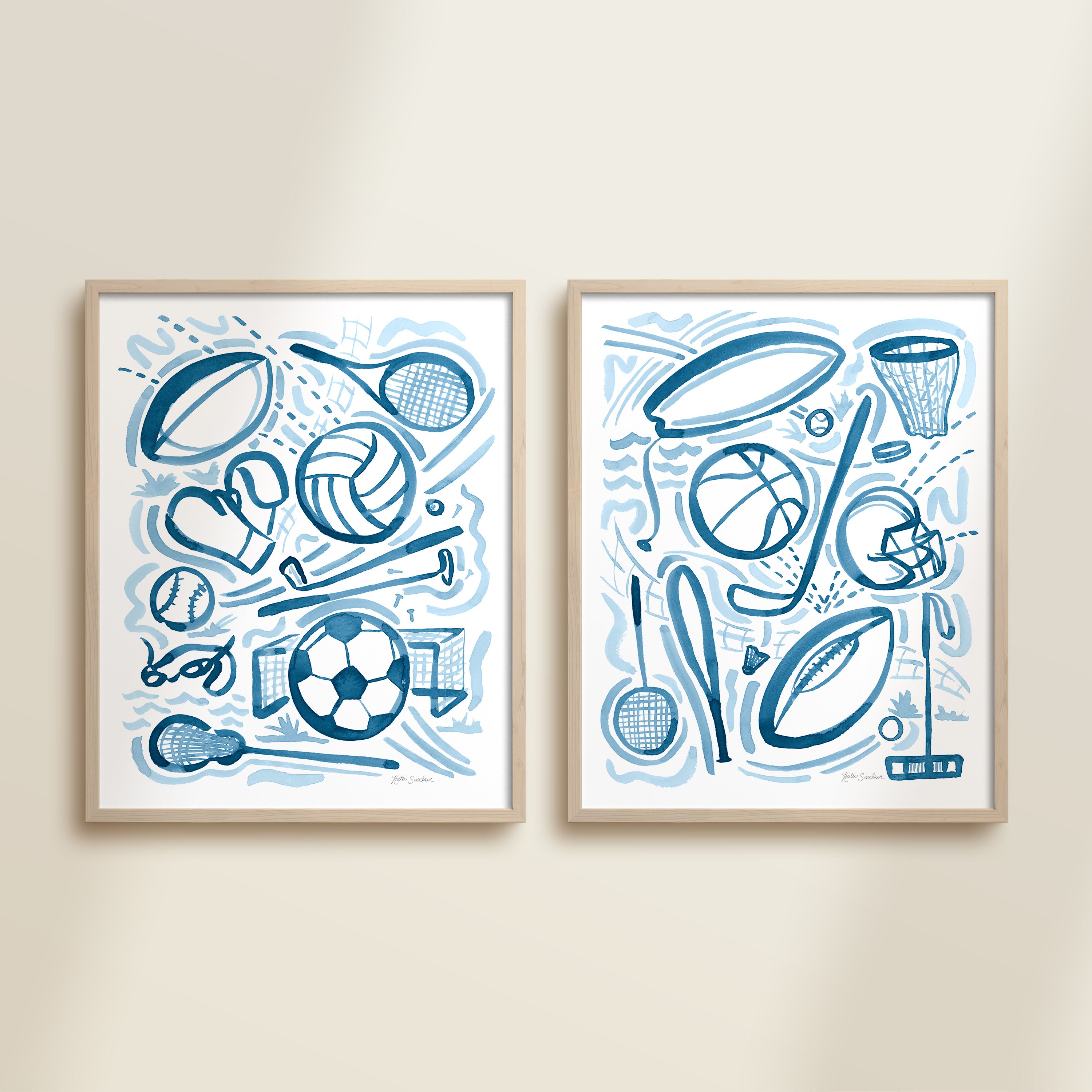 Two framed blue playful sports watercolor art prints in frames featuring tennis, soccer, ballet and baseball for kids nursery or playroom wall décor.  