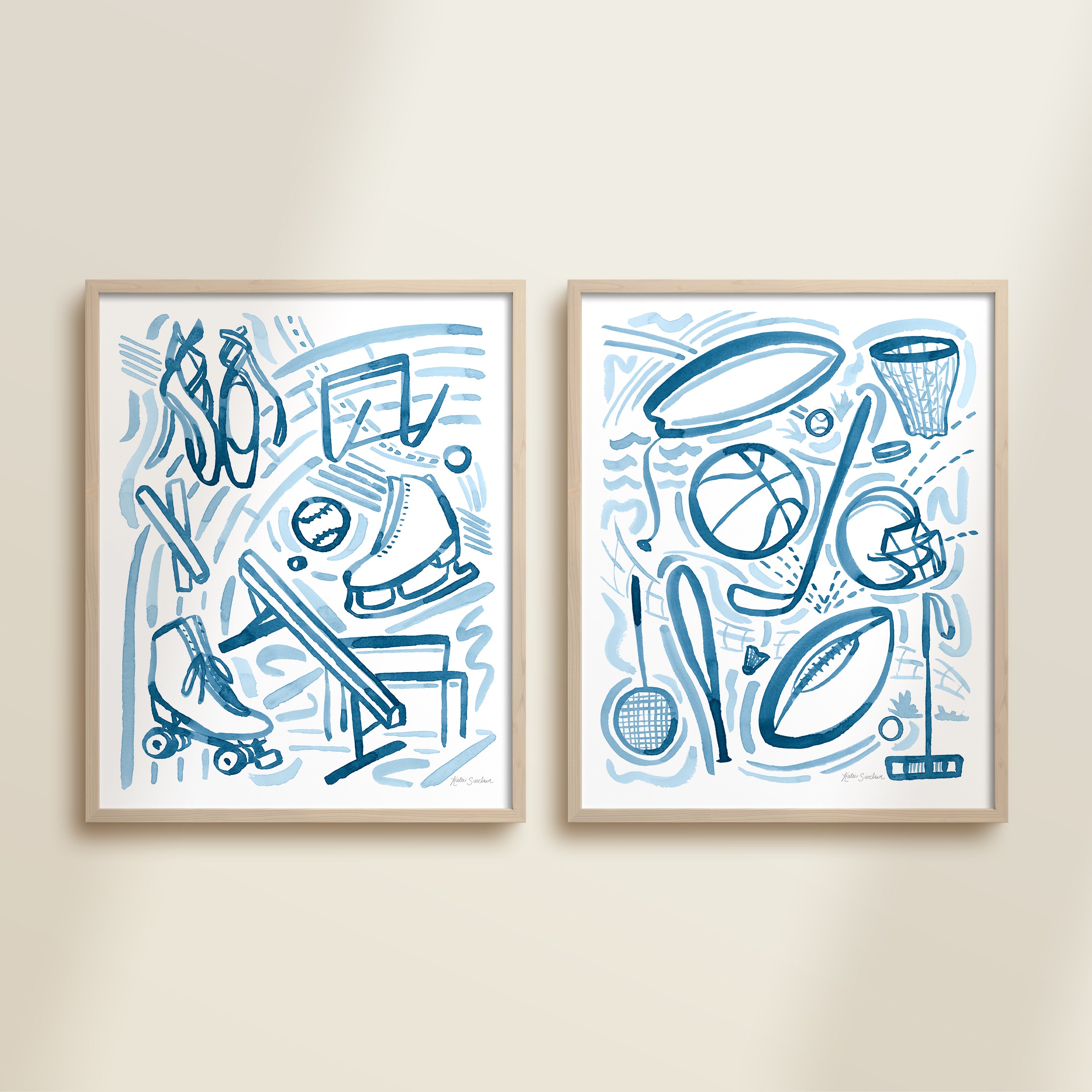 Two framed blue playful sports watercolor art prints in frames featuring tennis, soccer, ballet and baseball for kids nursery or playroom wall décor.