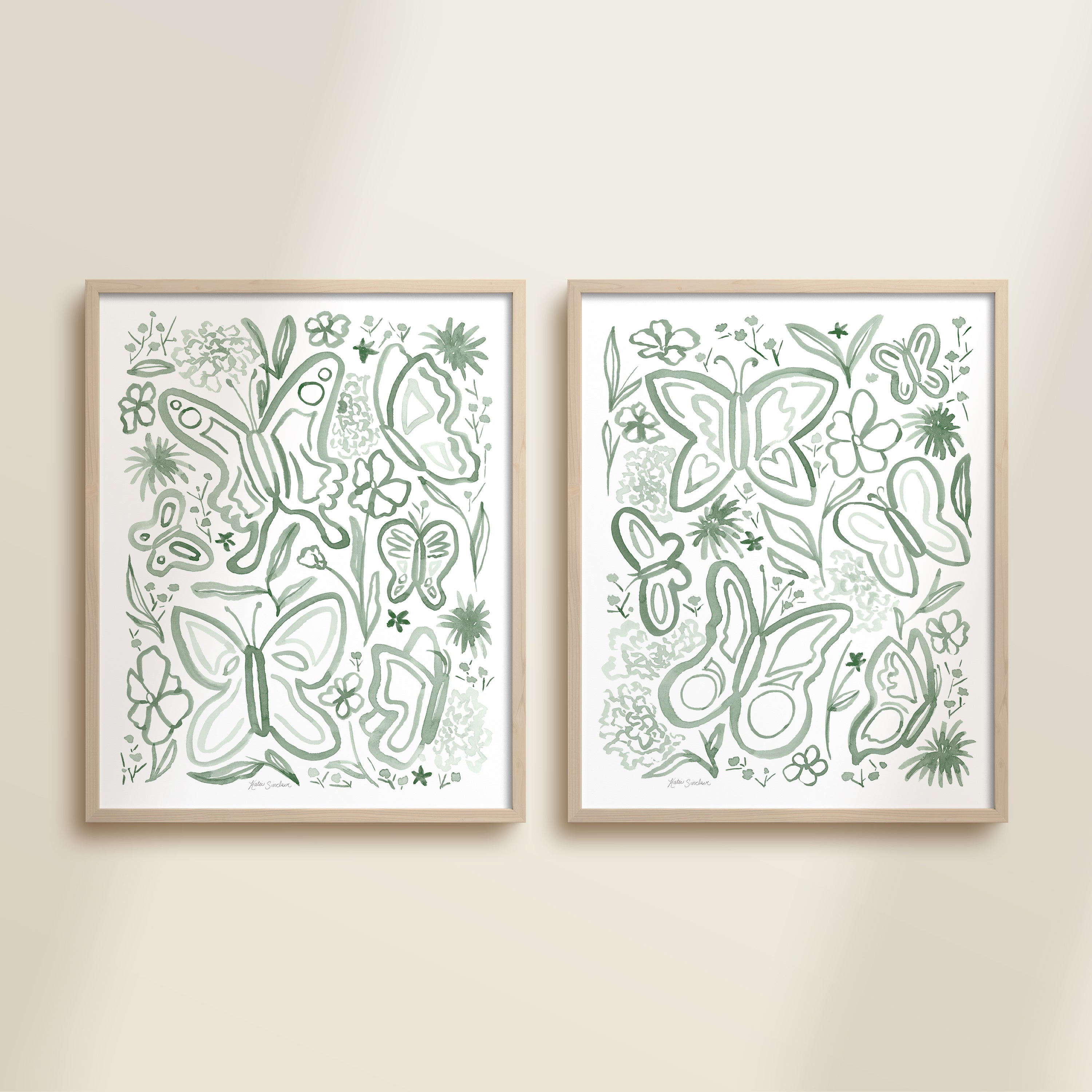 Two framed green watercolor garden-themed artworks on a beige wall, featuring a butterflies and flowers.