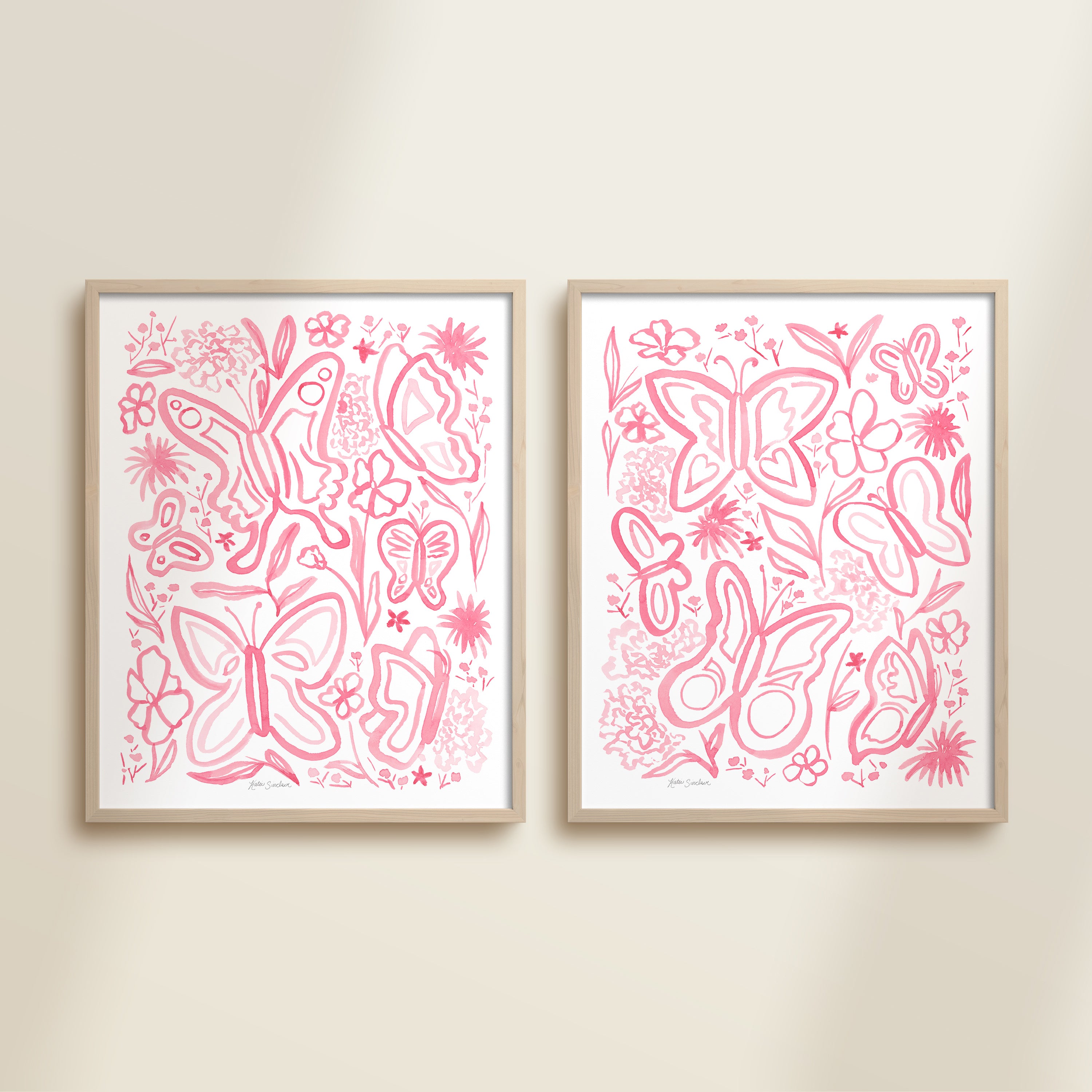 Two framed pink watercolor garden-themed artworks on a beige wall, featuring a butterflies and flowers.