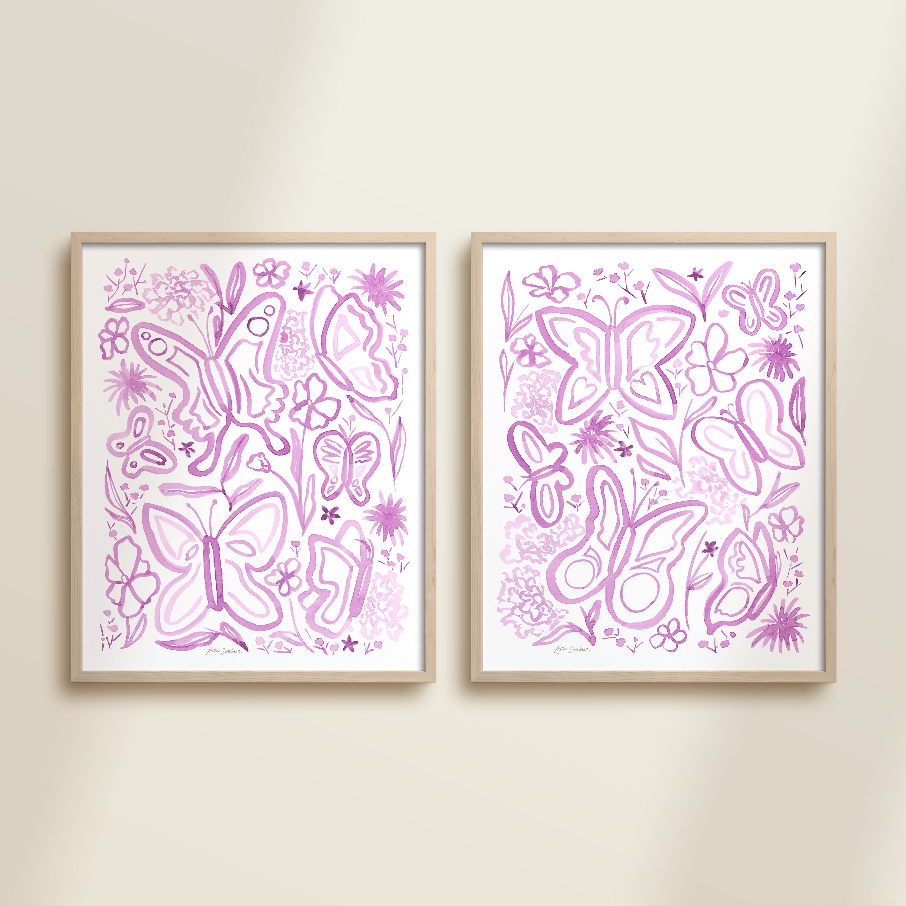 Two framed purple watercolor garden-themed artworks on a beige wall, featuring a butterflies and flowers.
