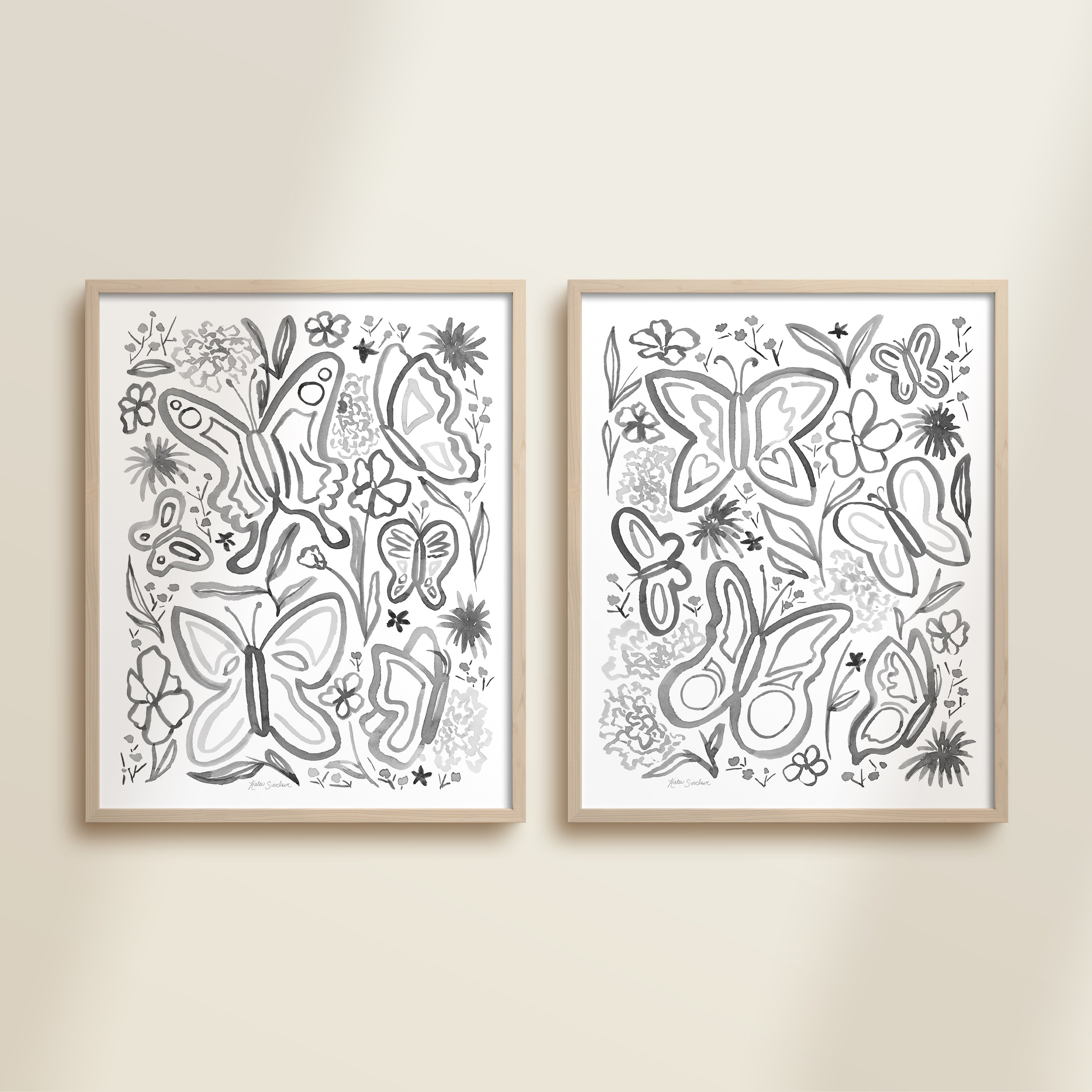 Two framed black and white watercolor garden-themed artworks on a beige wall, featuring a butterflies and flowers.