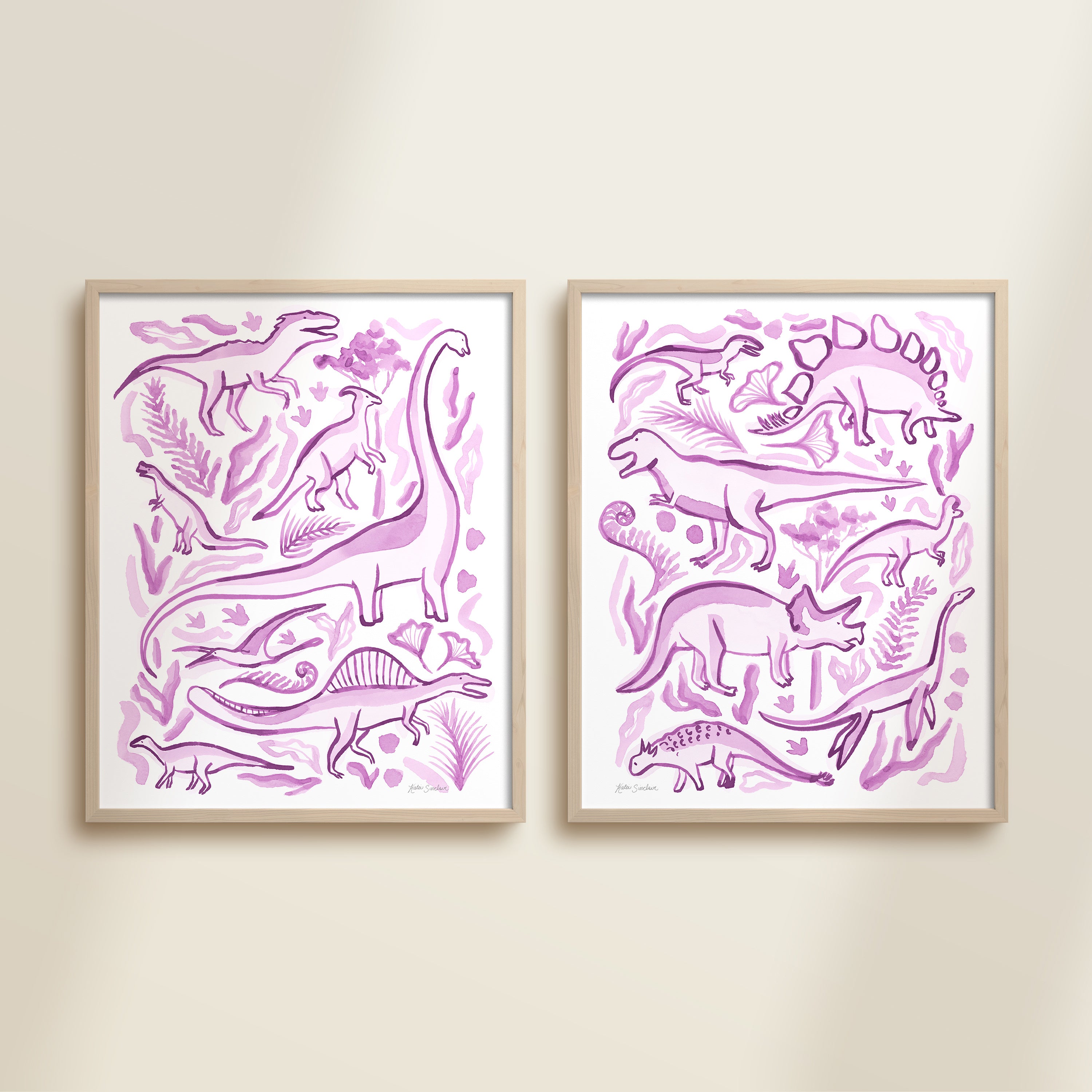 Two framed purple watercolor dinosaur-themed artworks on a beige wall, featuring a brontosaurus, t-rex, triceratops, raptor, spinosaurus, and plants.