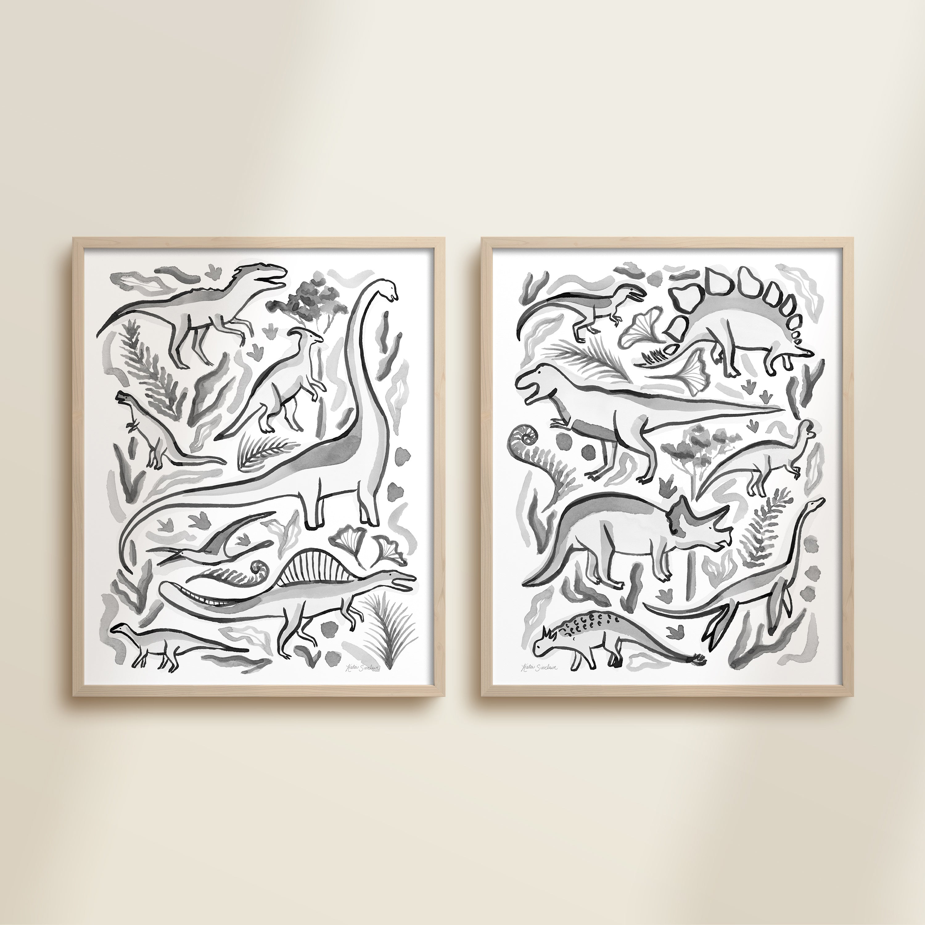 Two framed black and white watercolor dinosaur-themed artworks on a beige wall, featuring a brontosaurus, t-rex, triceratops, raptor, spinosaurus, and plants.