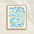 Framed hand-painted watercolor abstract artwork with colorful dinosaur illustrations on a light background, featuring a triceratops, T-Rex, and stegosaurus. 