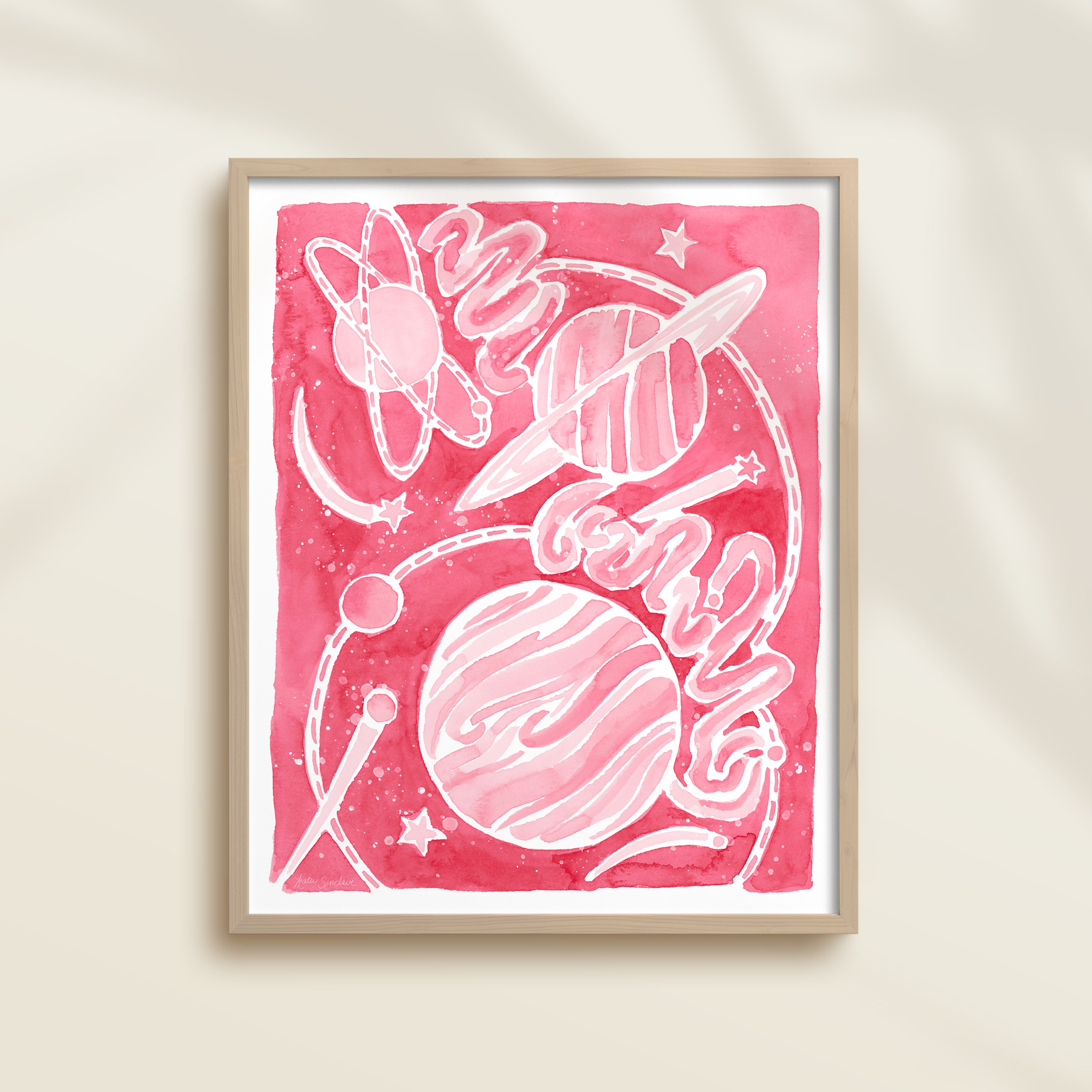 Framed pink watercolor artwork of space-themed design with planets, stars, and a galaxy.