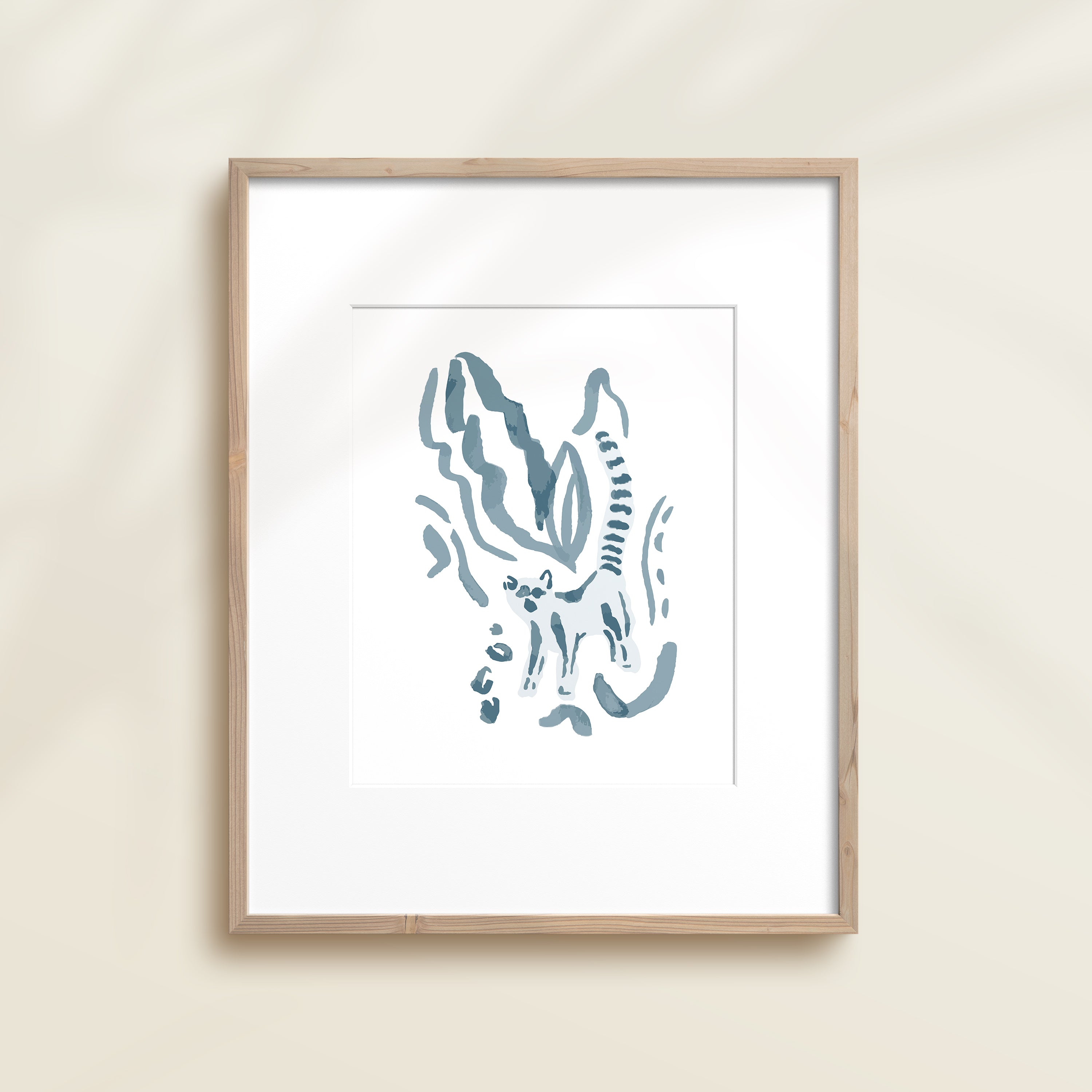 A framed watercolor print by Katie Sinclair of a lemur surrounded by  foliage, displayed on a wall.  This image showcases the blue color version.