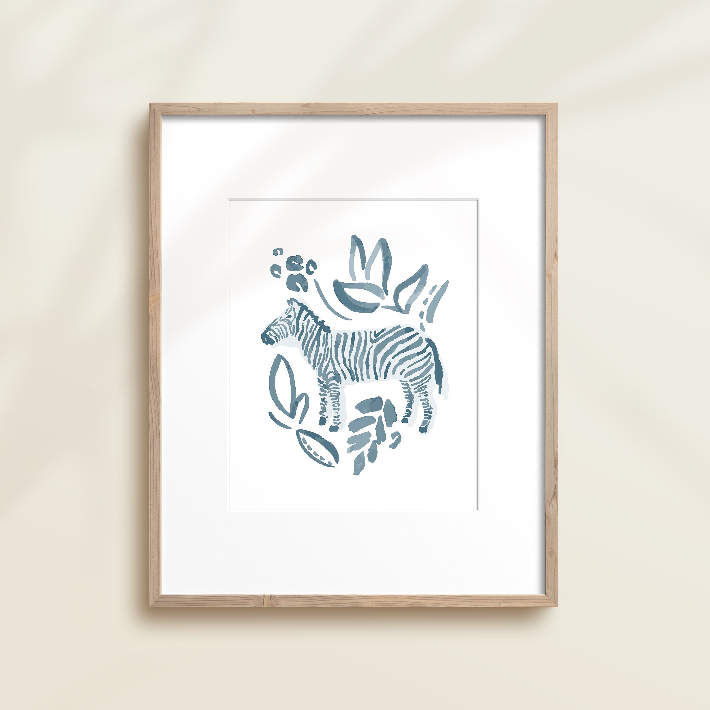 A framed watercolor print by Katie Sinclair of a zebra surrounded by  foliage, displayed on a wall.  This image showcases the blue color version.