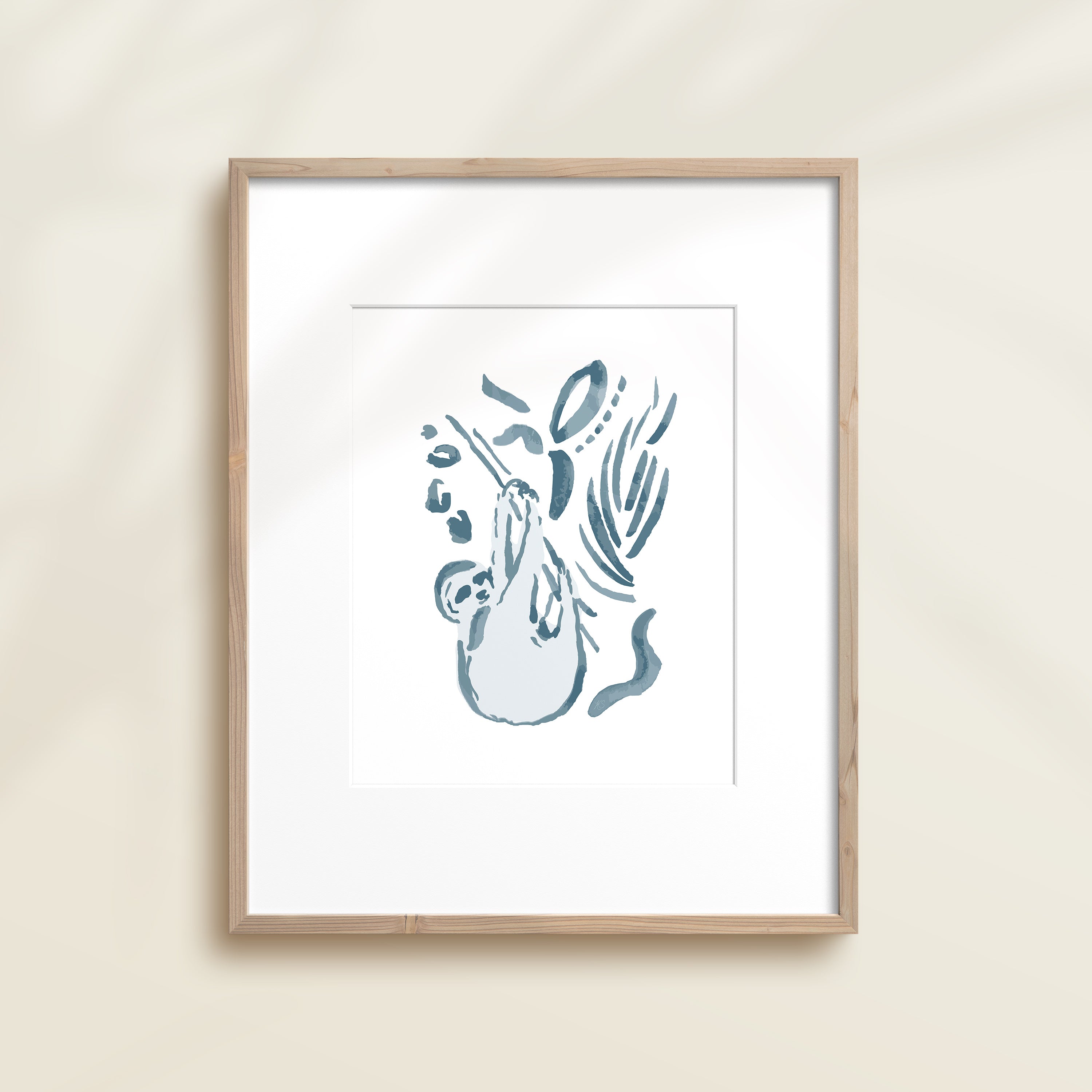 A framed watercolor print by Katie Sinclair of a sloth surrounded by  foliage, displayed on a wall.  This image showcases the blue color version.