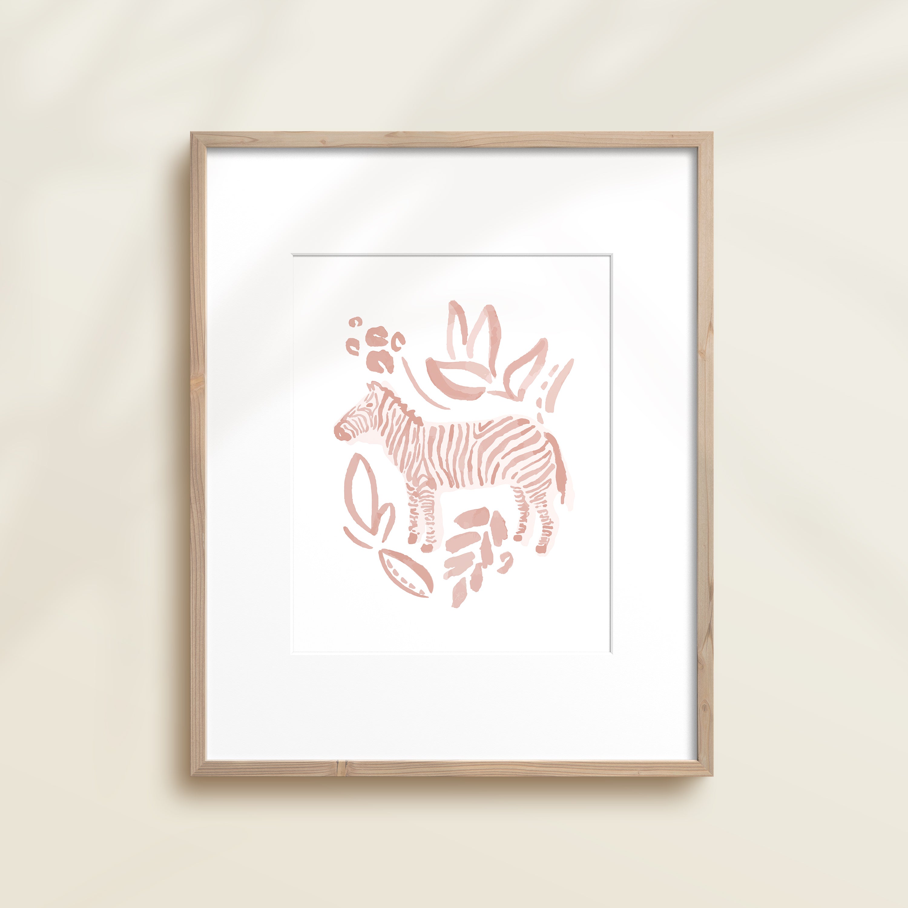 A framed watercolor print by Katie Sinclair of a zebra surrounded by  foliage, displayed on a wall.  This image showcases the pink color version.