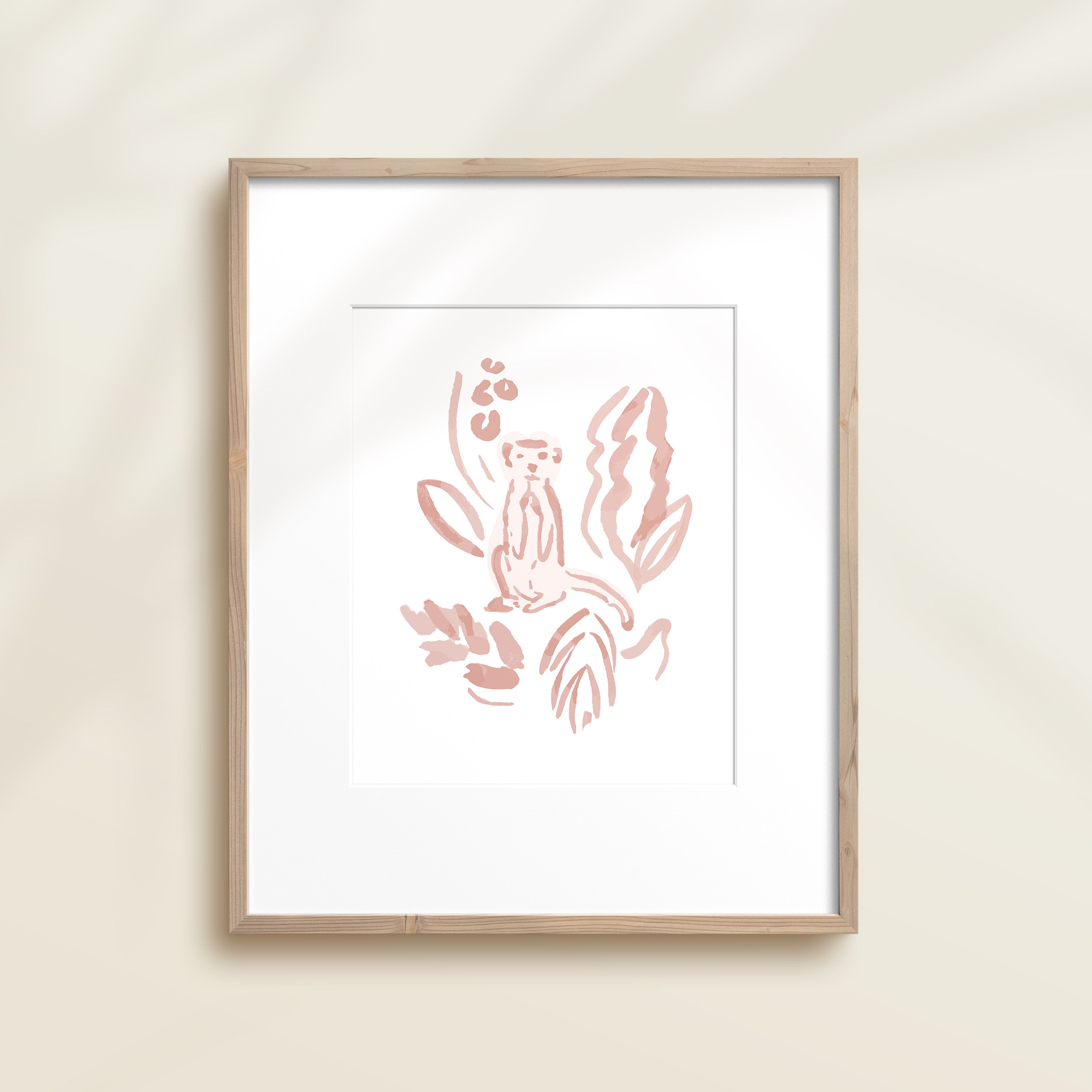 A framed watercolor print by Katie Sinclair of a meercat surrounded by  foliage, displayed on a wall.  This image showcases the pink color version.
