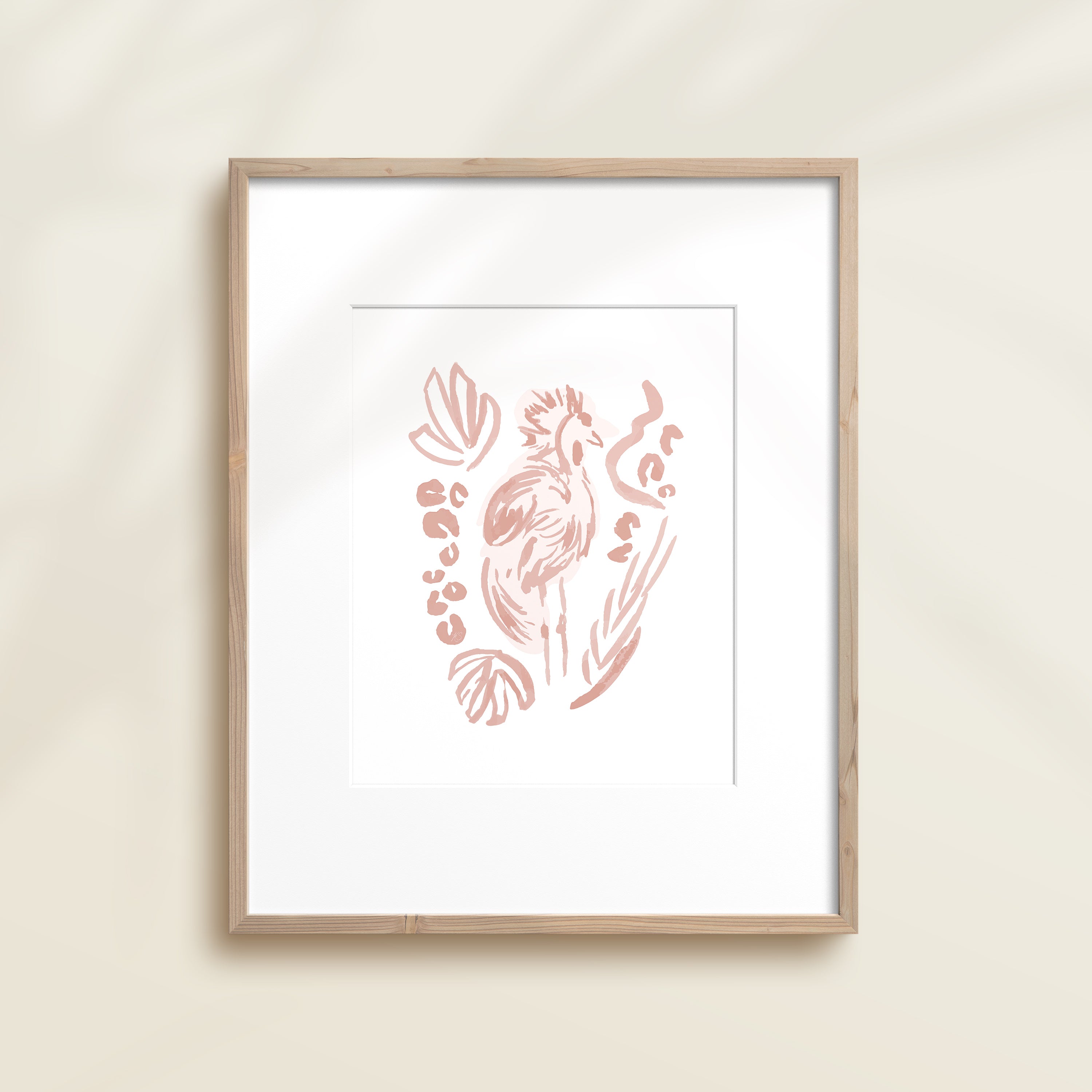A framed watercolor print by Katie Sinclair of a bird surrounded by  foliage, displayed on a wall.  This image showcases the pink color version.