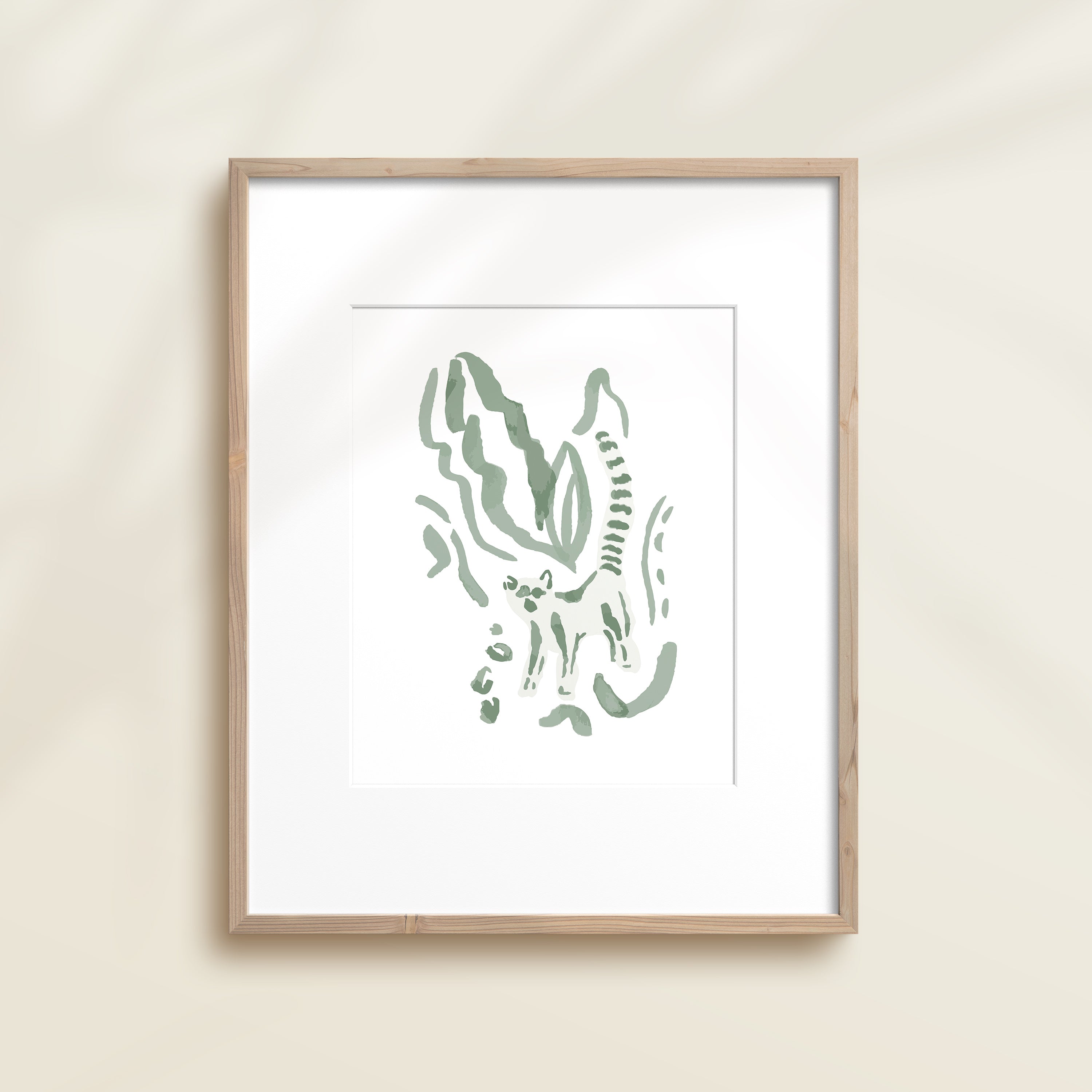 A framed watercolor print by Katie Sinclair of an lemur surrounded by  foliage, displayed on a wall.  This image showcases the green color version.