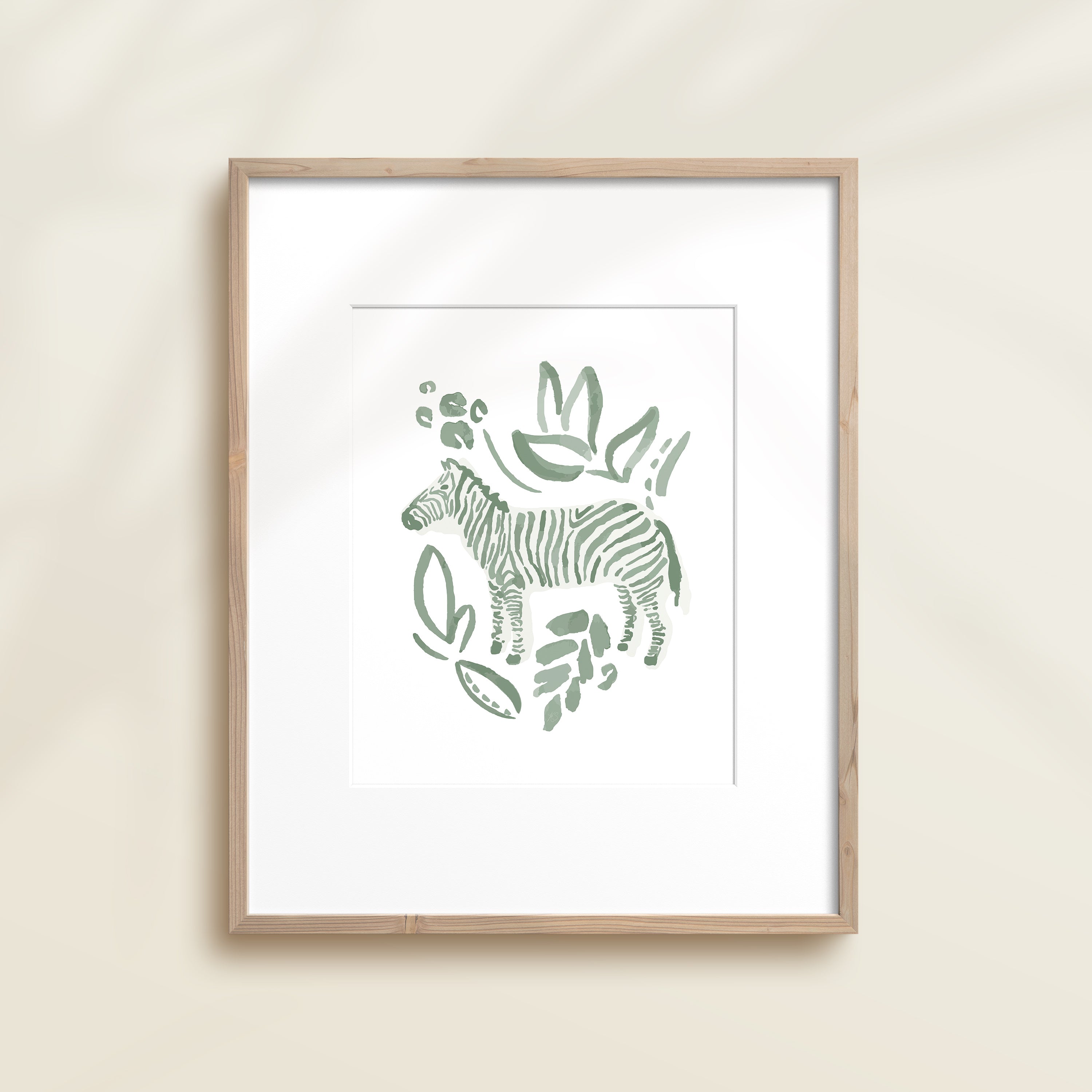 A framed watercolor print by Katie Sinclair of an zebra surrounded by  foliage, displayed on a wall.  This image showcases the green color version.