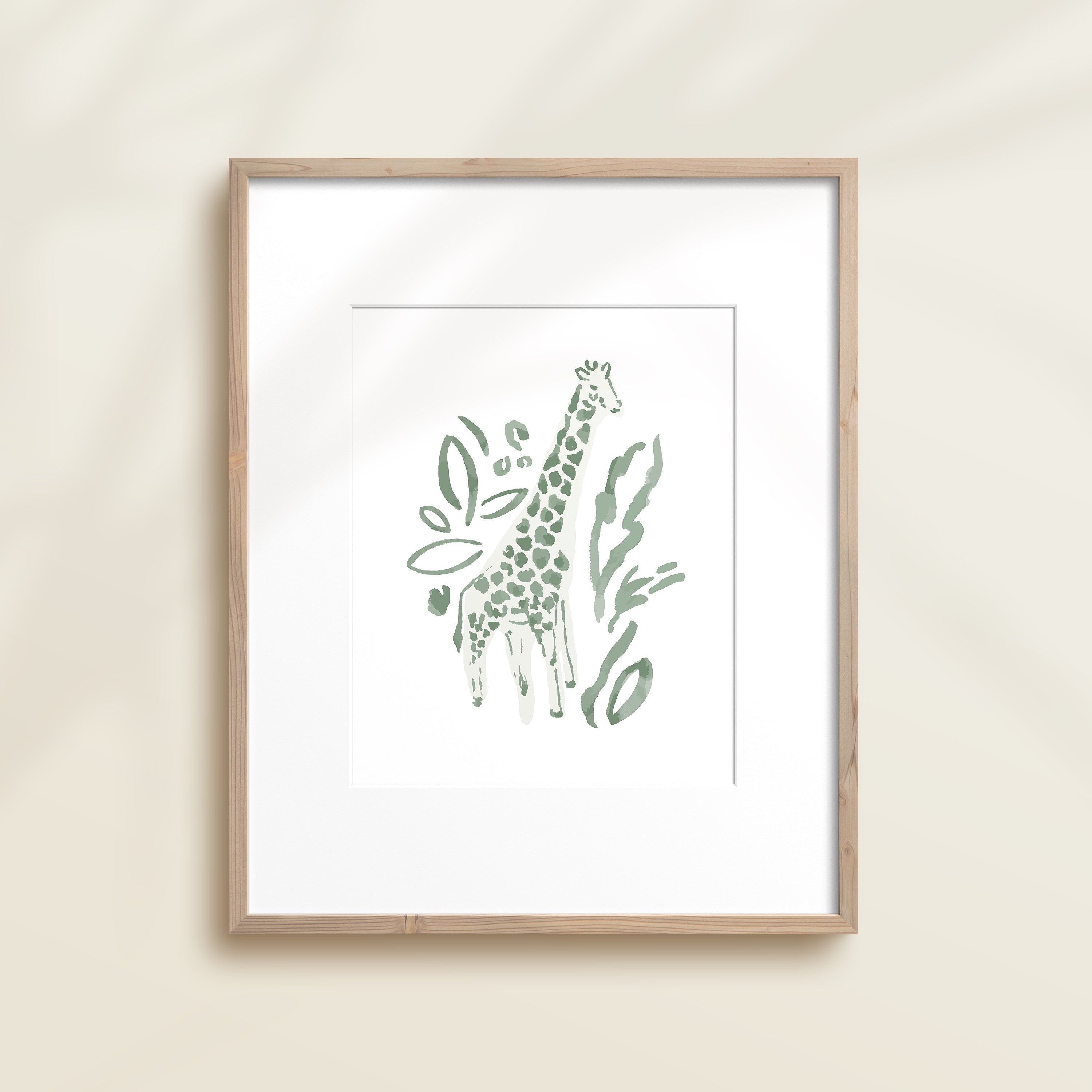 A framed watercolor print by Katie Sinclair of an giraffe surrounded by  foliage, displayed on a wall.  This image showcases the green color version.