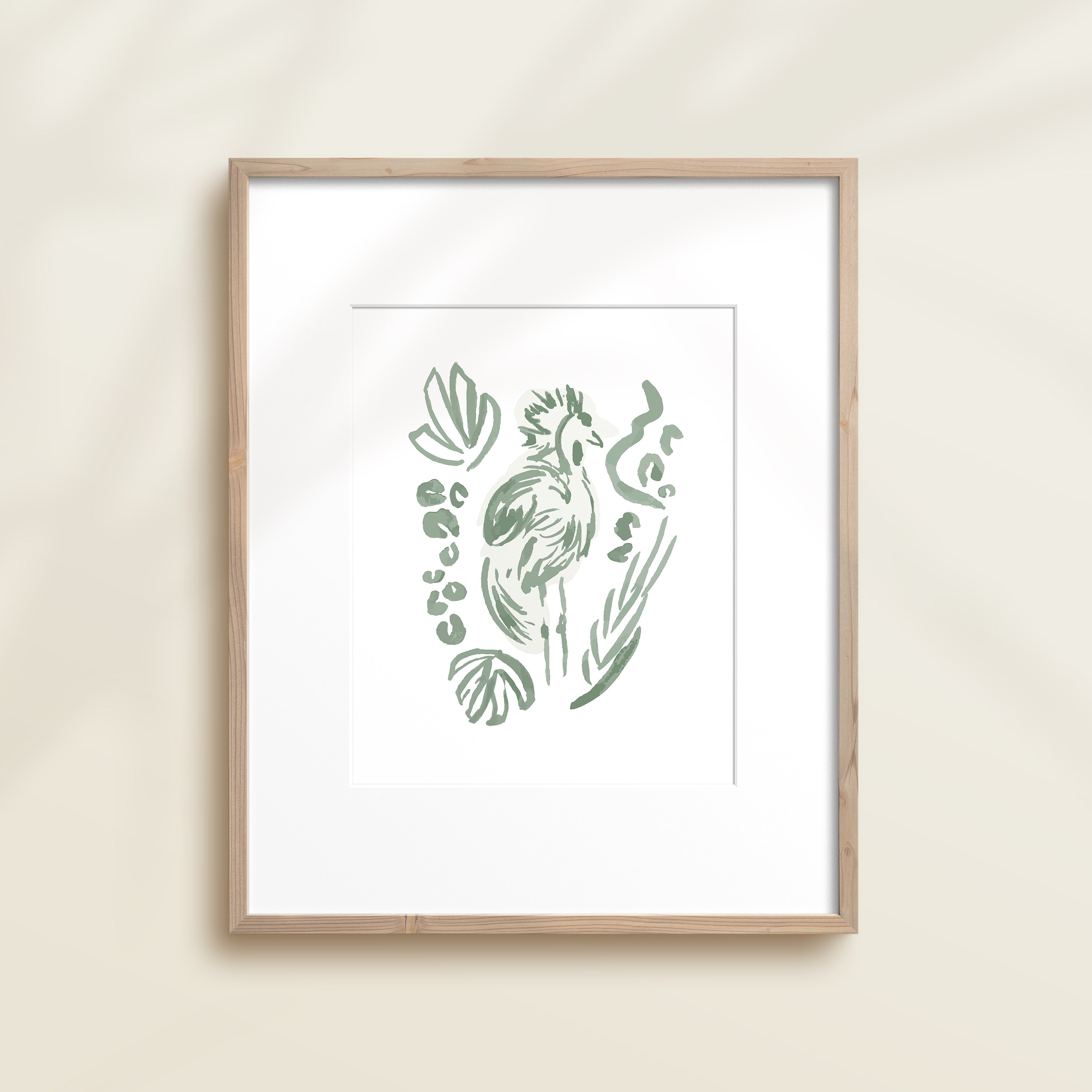 A framed watercolor print by Katie Sinclair of an tropical bird surrounded by  foliage, displayed on a wall.  This image showcases the green color version.