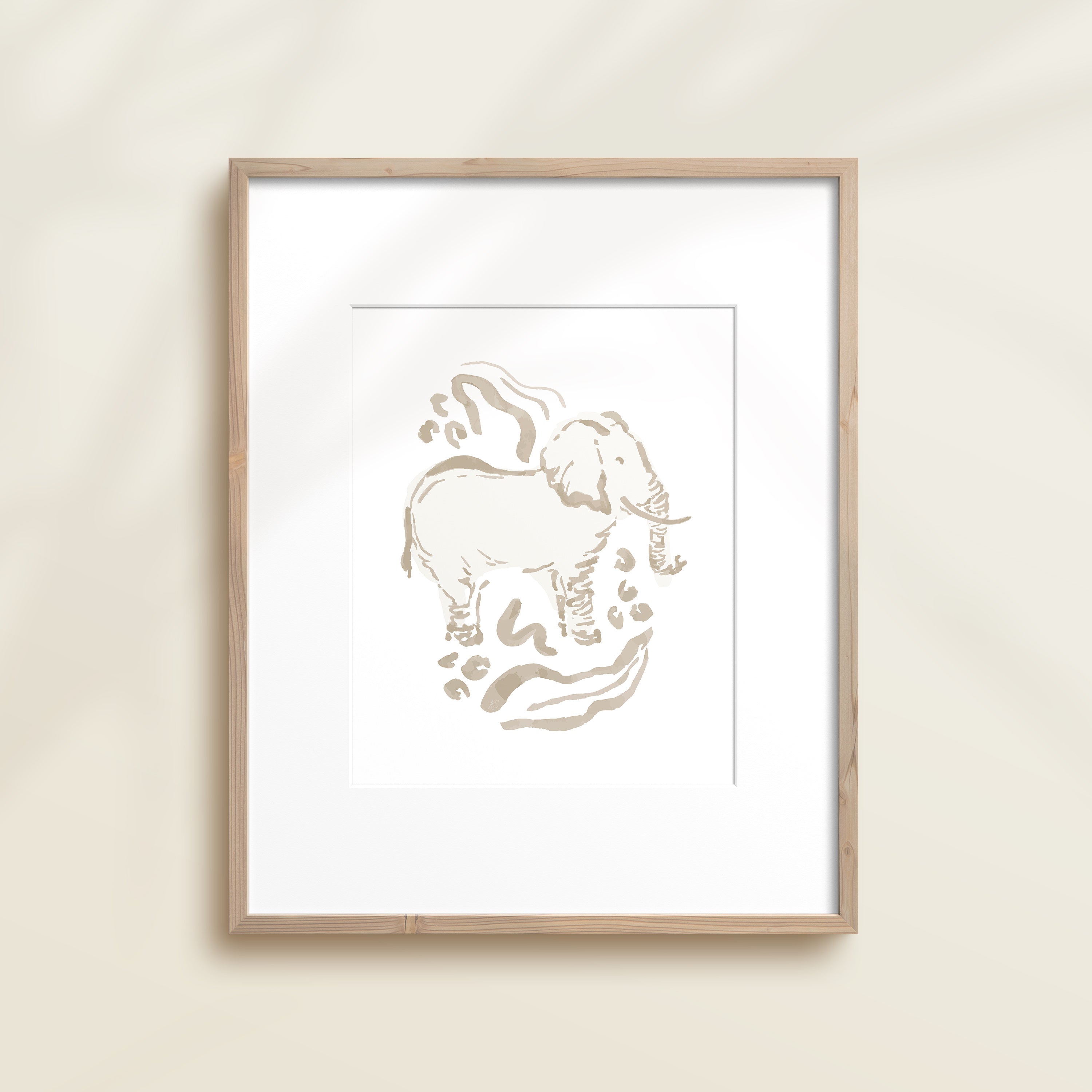 A framed watercolor print by Katie Sinclair of an elephant surrounded by  foliage, displayed on a wall.  This image showcases the gray color version.