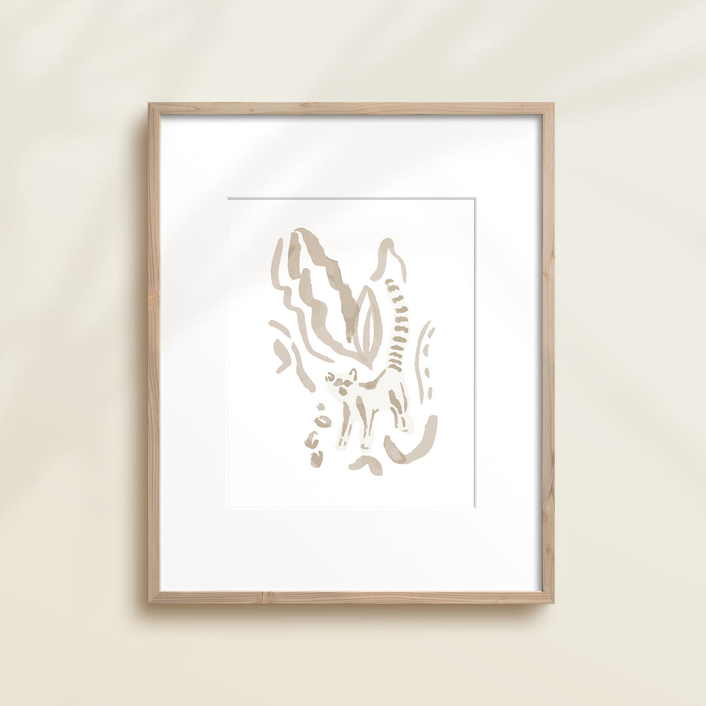 A framed watercolor print by Katie Sinclair of an lemur surrounded by  foliage, displayed on a wall.  This image showcases the gray color version.