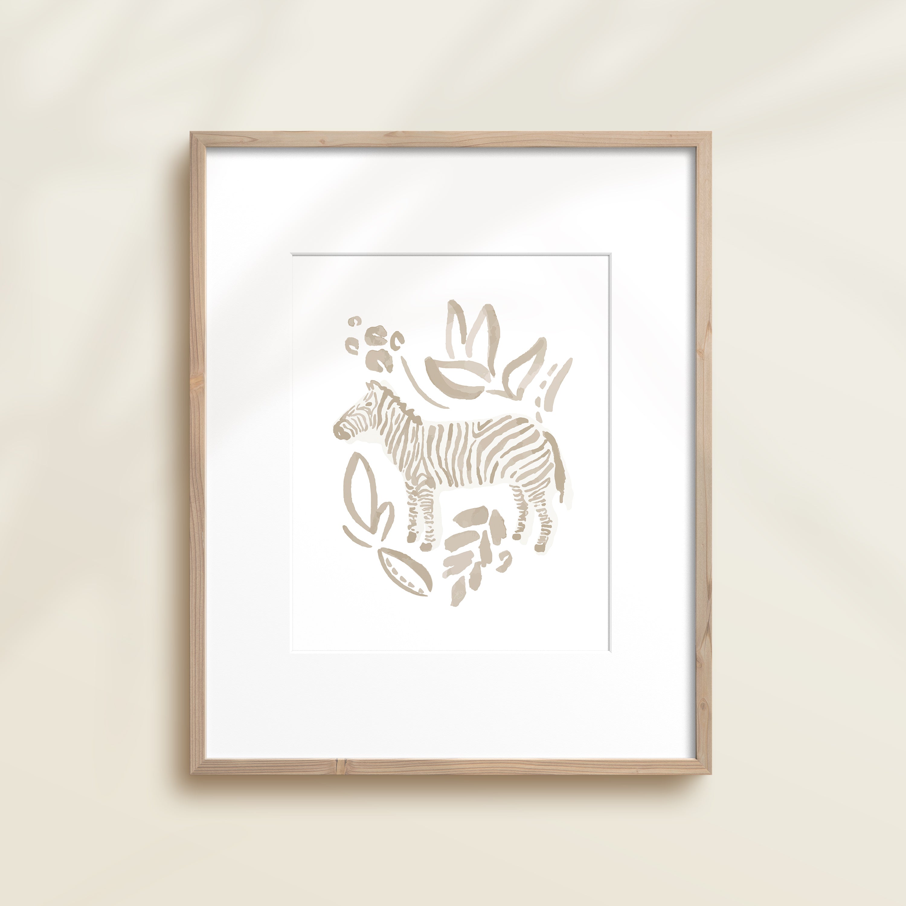 A framed watercolor print by Katie Sinclair of an zebra surrounded by  foliage, displayed on a wall.  This image showcases the gray color version.