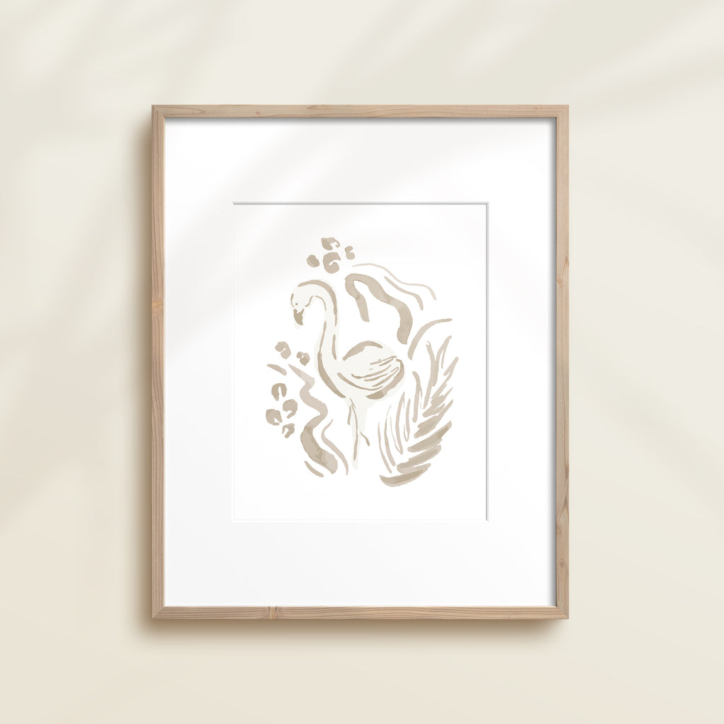 A framed watercolor print by Katie Sinclair of an flamingo surrounded by  foliage, displayed on a wall.  This image showcases the gray color version.