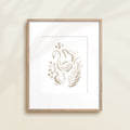 A framed watercolor print by Katie Sinclair of an flamingo surrounded by  foliage, displayed on a wall.  This image showcases the gray color version.