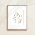 A framed watercolor print by Katie Sinclair of an flamingo surrounded by  foliage, displayed on a wall.  This image showcases the gray color version.