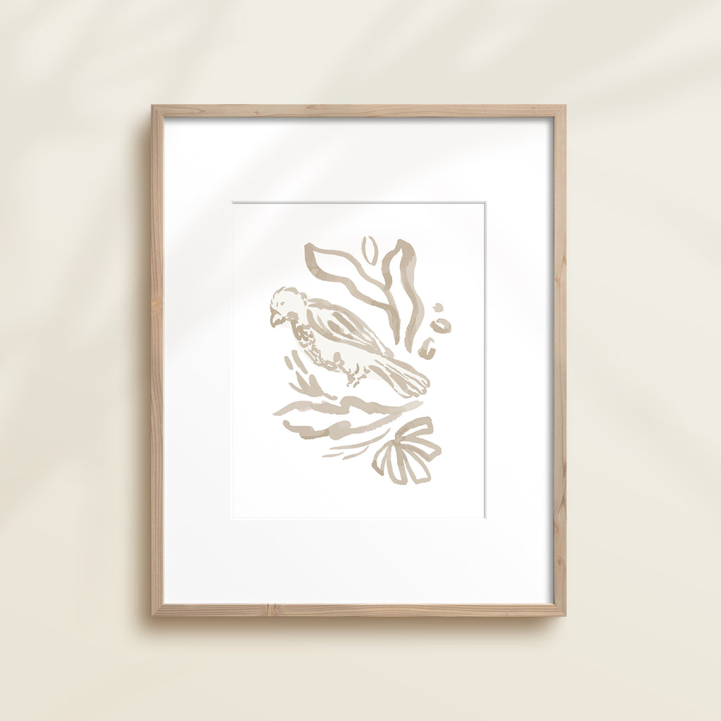 A framed watercolor print by Katie Sinclair of an bird surrounded by  foliage, displayed on a wall.  This image showcases the gray color version.