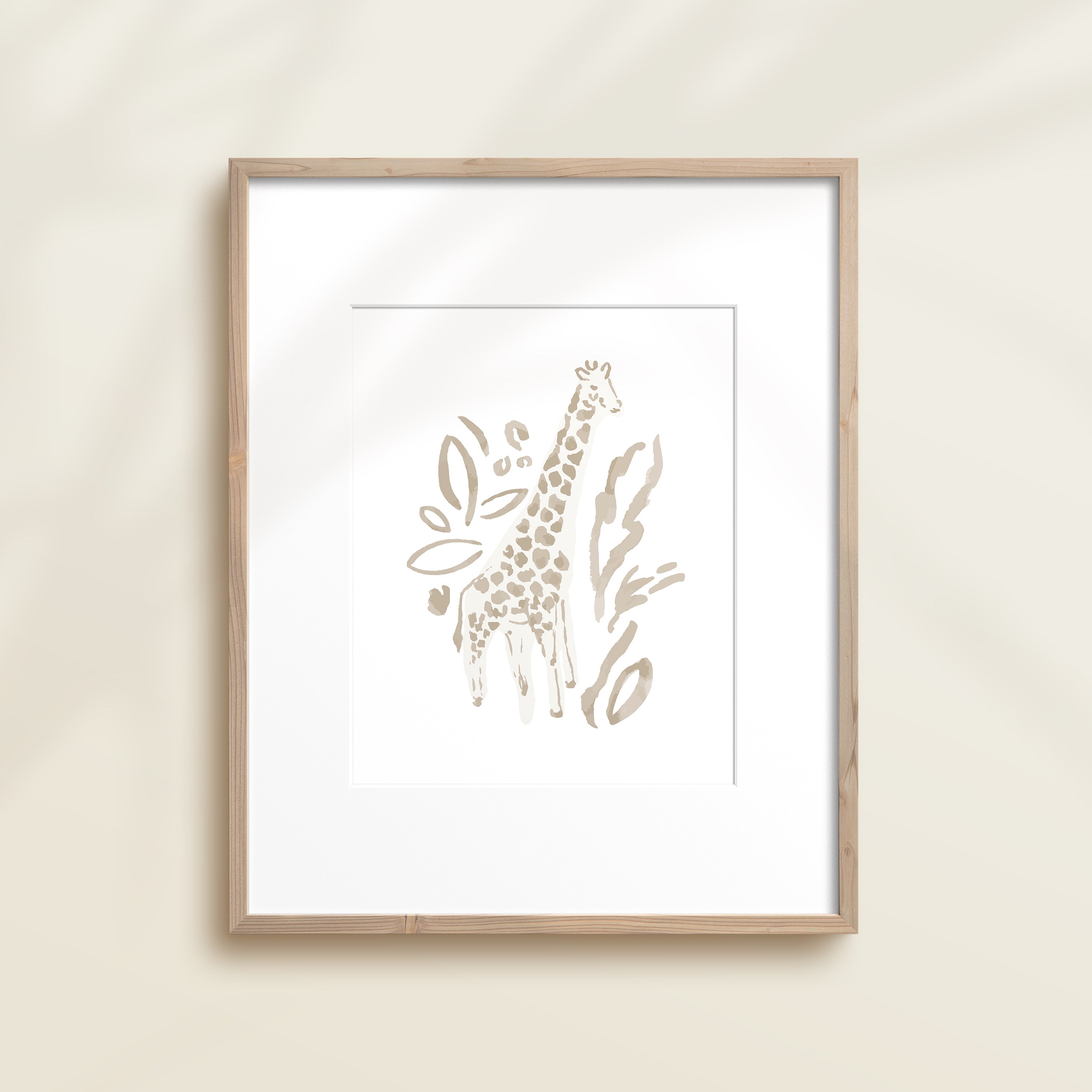 A framed watercolor print by Katie Sinclair of an giraffe surrounded by  foliage, displayed on a wall.  This image showcases the gray color version.