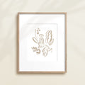 A framed watercolor print by Katie Sinclair of an meercat surrounded by  foliage, displayed on a wall.  This image showcases the gray color version.