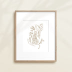 A framed watercolor print by Katie Sinclair of an tiger surrounded by  foliage, displayed on a wall.  This image showcases the gray color version.