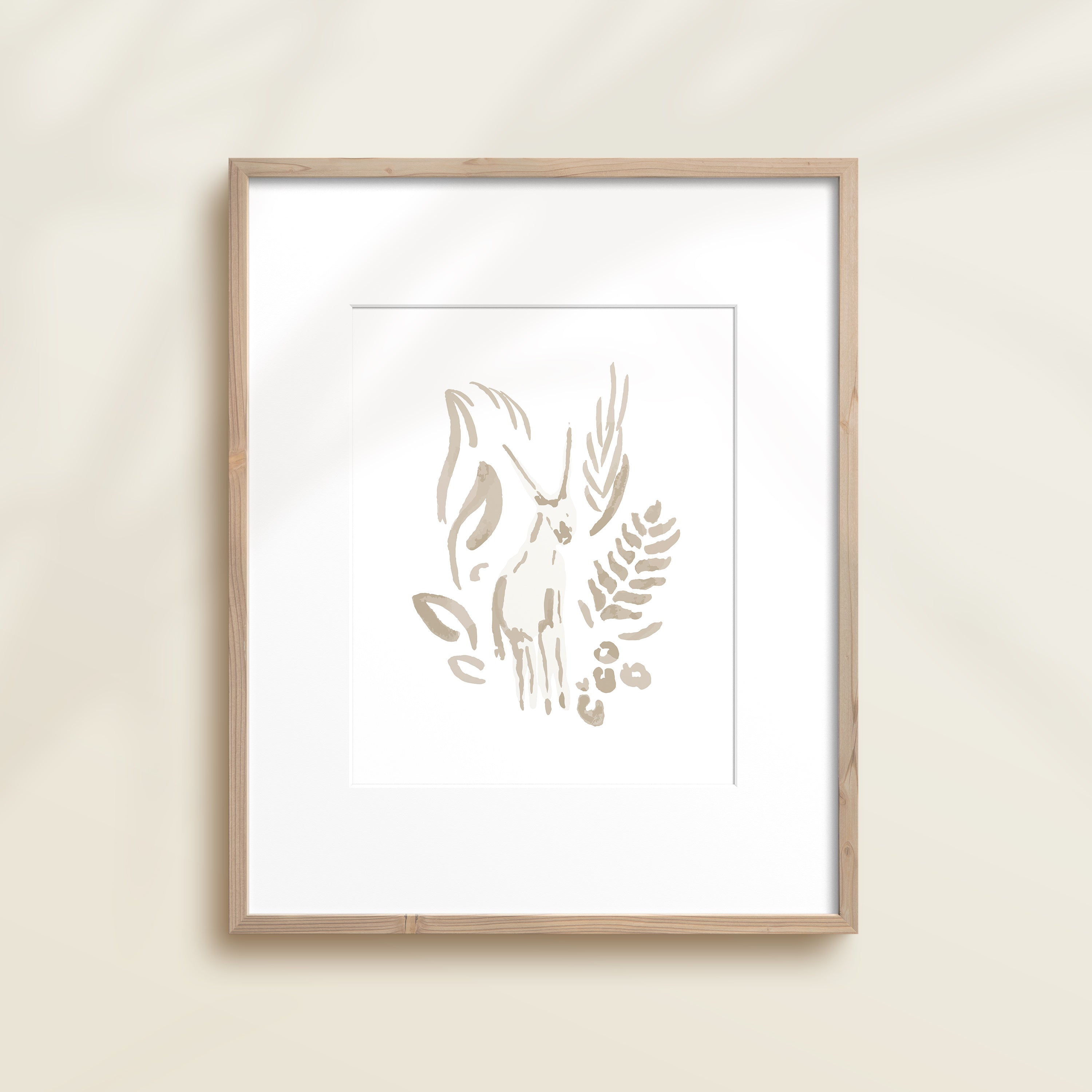 A framed watercolor print by Katie Sinclair of an antelope surrounded by  foliage, displayed on a wall.  This image showcases the gray color version.